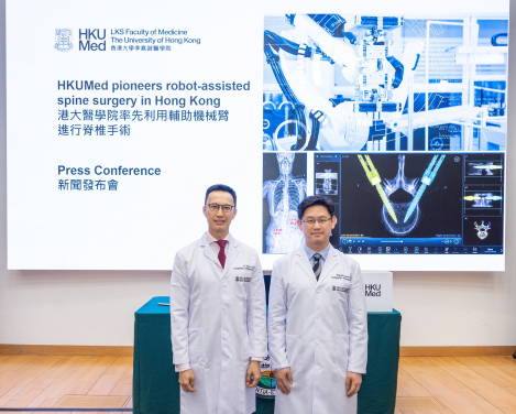 HKUMed researchers Professor Jason Cheung Pui-yin (right) and Dr Kenny Kwan Yat-hong share details of their first robot-assisted spine surgery in Hong Kong.
 